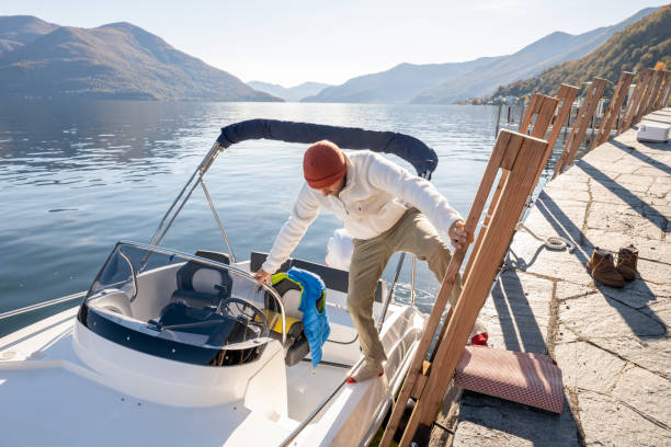 istock Young man docking a boat on a small jetty by the lake 1360230646