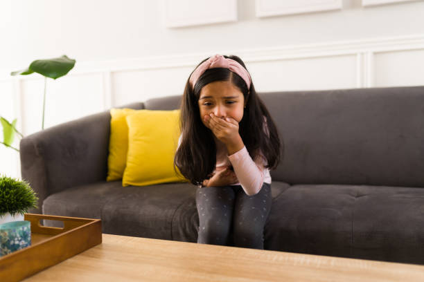 Upset latin kid is going to puke Hispanic girl feels ill and covering her mouth because of the nausea. Little girl suffering from stomach ache wants to vomit puke stock pictures, royalty-free photos & images