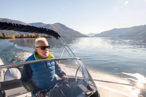 istock Man piloting a boat on a calm sunny day on the lake 1360231731