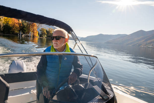 istock Man piloting a boat on a calm sunny day on the lake 1360231790
