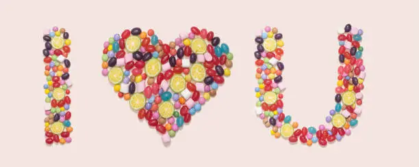 Photo of Romantic sweet minimal concept. I love you symbol made of many different jelly beans and candies against pink champagne background. Flat lay arrangement