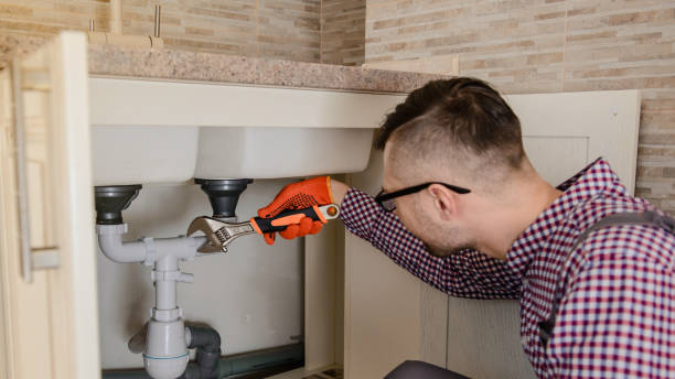 istock installer fixes with wrench the water tap pipe in vintage kitchen 1360236667