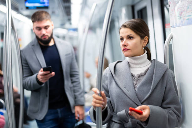istock Woman with smartphone in subway car 1360238841