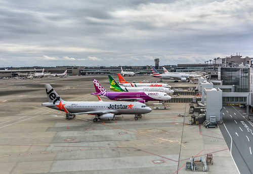 tokyo, japan - december 06 2021: Boeing and airbus planes from Japanese low-cost carriers or low-cost airlines parked on the apron or tarmac of the Narita international airport a cloudy day.