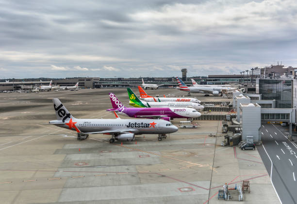 Planes from Japanese low-cost airlines parked on the apron of the Narita international airport. tokyo, japan - december 06 2021: Boeing and airbus planes from Japanese low-cost carriers or low-cost airlines parked on the apron or tarmac of the Narita international airport a cloudy day. narita japan stock pictures, royalty-free photos & images