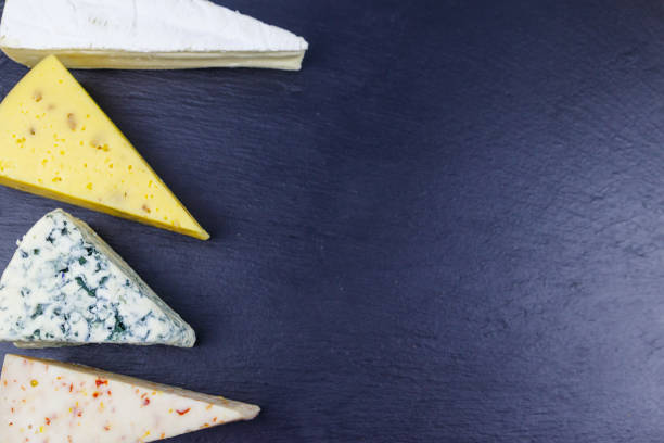 istock Set of various types of cheese on black slate background. Top view 1360243040