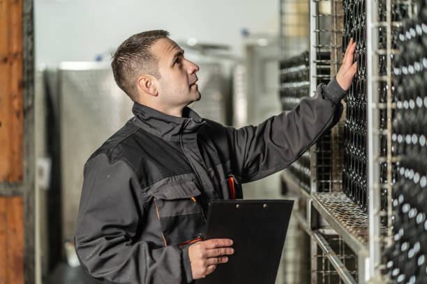istock Side view of adult man winemaker at winery checking quality while standing between the silos controlling alcohol drink fermentation process - real people traditional and industry wine making concept 1360244320