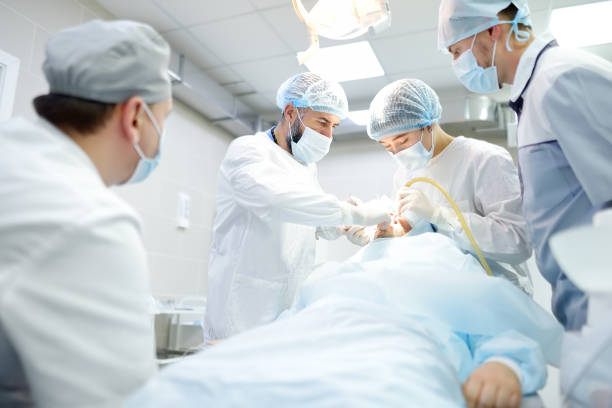 istock Surgeon and nurse during a dental operation. Anesthetized patient in the operating room. Installation of dental implants in the clinic. 1360244498