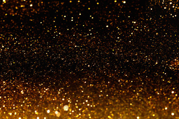 istock Gold dust, golden glitter on black background. 1360244666