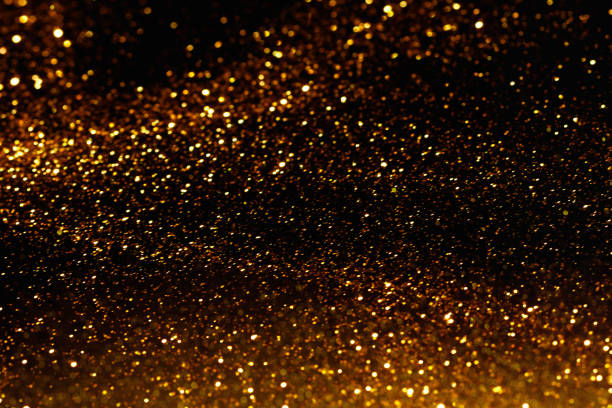 istock Gold dust, golden glitter on black background. 1360244679