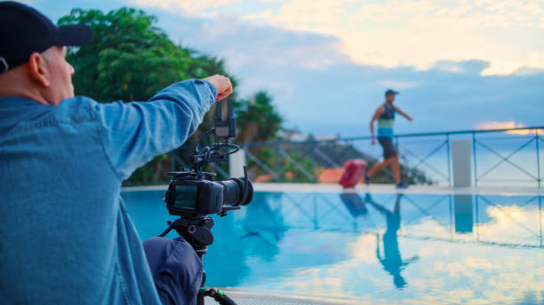 istock Infinity pool on a patio. Man with suitcase posing for a photo. Photographer giving tips 1360246812