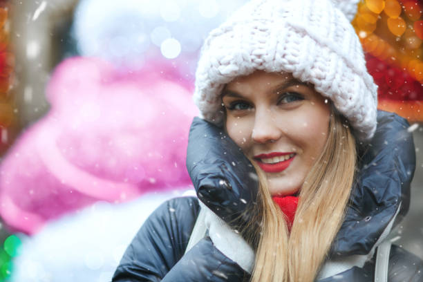 istock Charming lady walking at the winter fair with snowflakes 1360247011