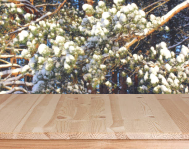 istock Empty wooden table with winter branches in the background 1360248997