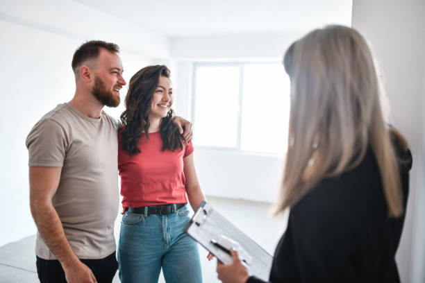 istock Smiling Couple Happy With Apartment While Taking A Look At It With Real Estate Agent 1360249892