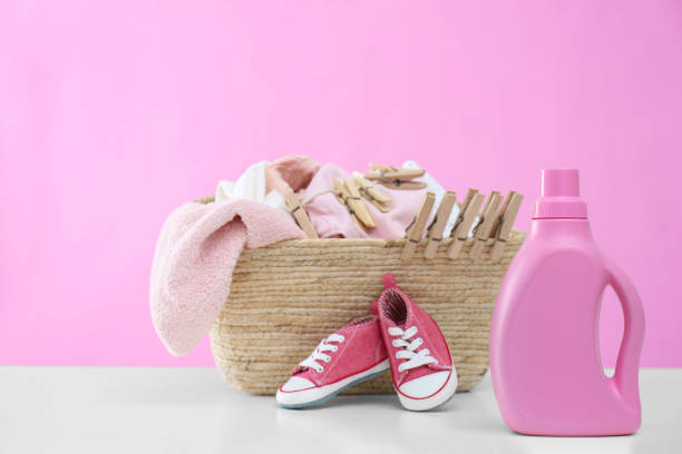 istock Detergent and children's clothes on white table 1360250357