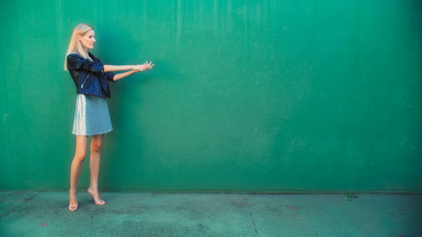 Woman putting up gray wallpaper