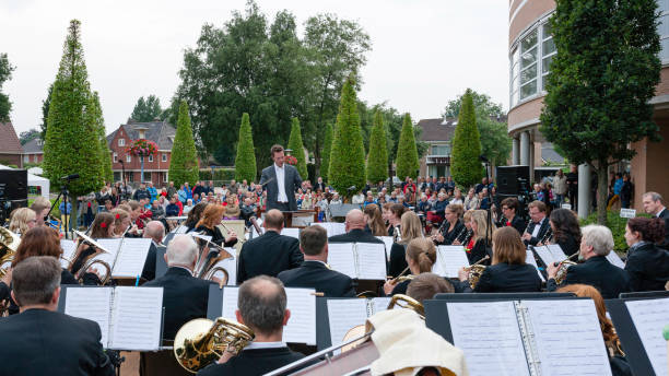 pubblico che ascolta un concerto all'aperto gratuito dell'orchestra locale - conductor female women classical concert foto e immagini stock