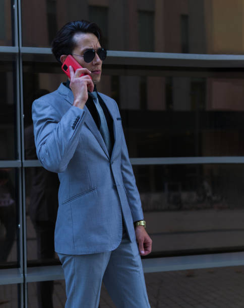 istock handsome business man dressed in formal suit making a call with his mobile phone. 1360251416