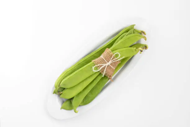 Photo of Flat Long Green Vegetable Runner Beans Known As Jhar Sim, Falia, Keralan, Sem Ki Phali, Surti Papdi, Guar Ki Fali, Gawar Isolated On White Background. Used To Cook Curry Bhaji Sabji Or Hari Sabzi