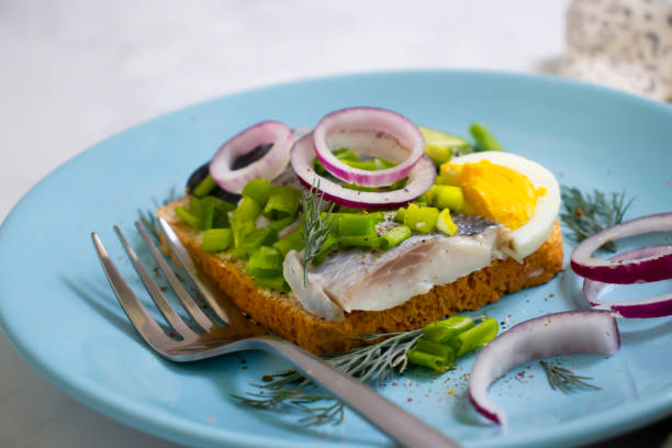 istock herring sandwich blue onion on wooden background 1360255700