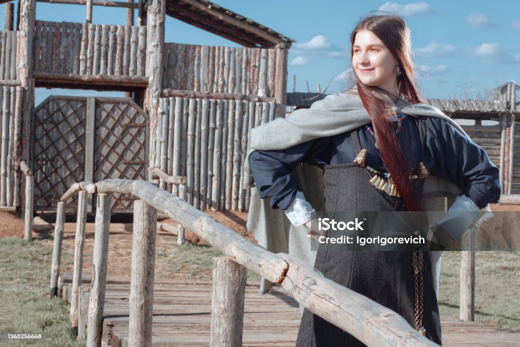 Scandinavian woman Scandinavian middle class woman in  historical suit posing over village. Her apparel based on archaeological sites on  Island of Gotland. Late 10th - 11th centuries. Viking Stock Photo