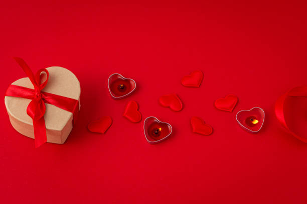 istock Saint Valentine top view composition with gift box, candles, hearts on red background 1360256716