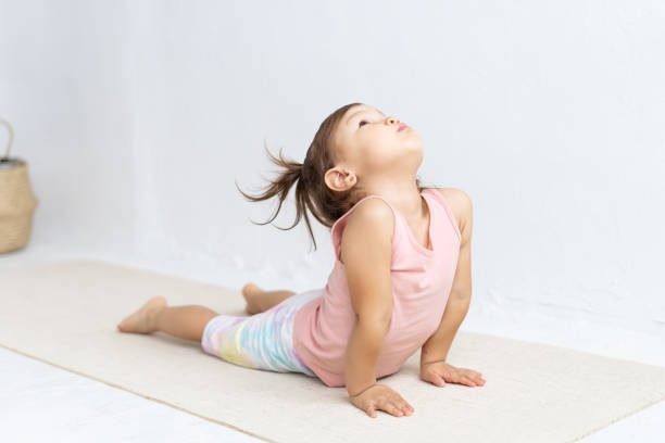 요가를 연습하는 어린 스포티 한 소녀, 아르다 bhudjangasana 운동을하고. 아기 코브라 포즈. - child exercising sport yoga 뉴스 사진 이미지