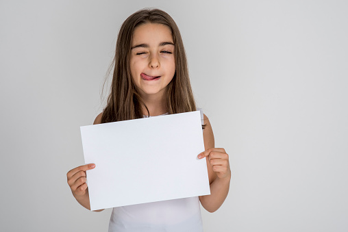 Child girl holding white sheet blank isolated