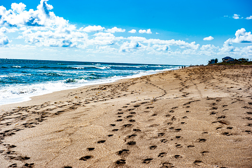 Foot prints in the sand along the beach coastline on Jupiter Beach in Jupiter, Florida.  Jupiter is the northernmost town in Palm Beach County, Florida, United States.