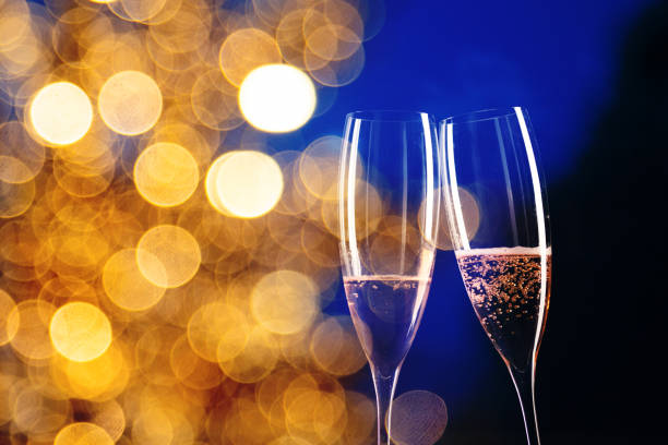 istock two champagne glasses and festive light happy New Year 1360264957