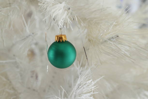 istock Green Christmas Ornament on a White Tree 1360264990