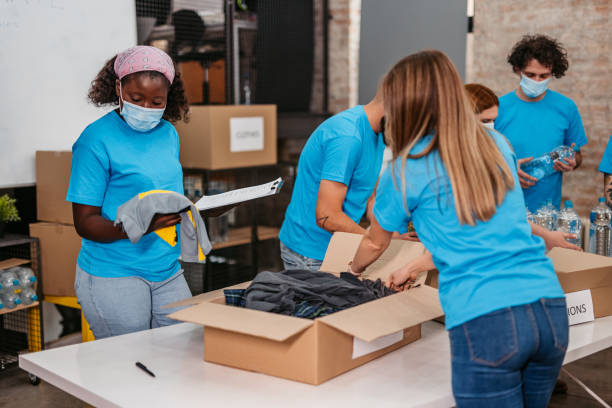 istock Volunteers packing food and clothes in donation boxes 1360266033