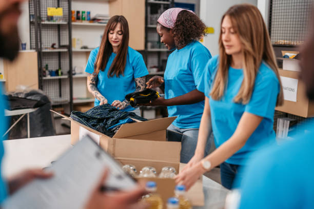 istock Volunteers packing food and clothes in donation boxes 1360266748