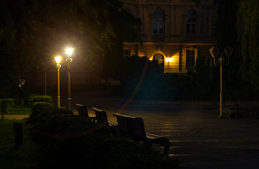 night street old town square with university campus with lantern lights, unfocused concept of photography, empty space, wooden bench