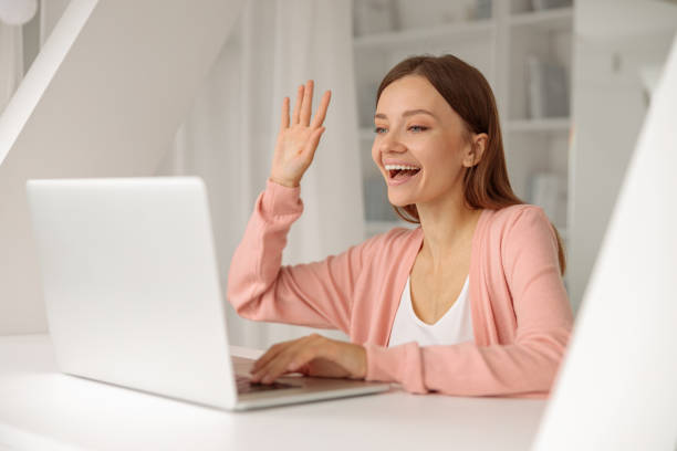 istock Smiling pretty woman using laptop while having video call 1360268333