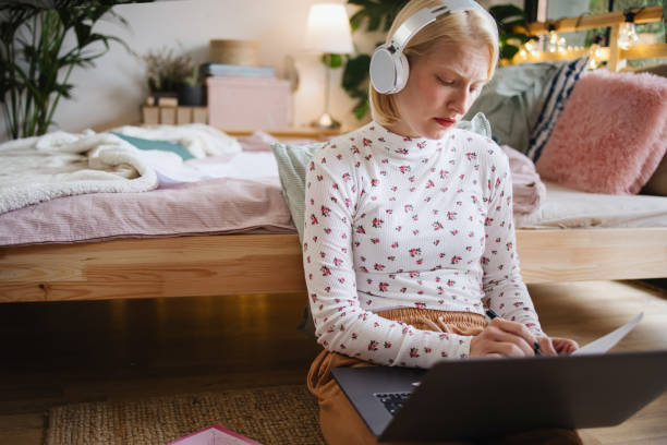 istock Young student taking notes from laptop and books for her exams 1360271226