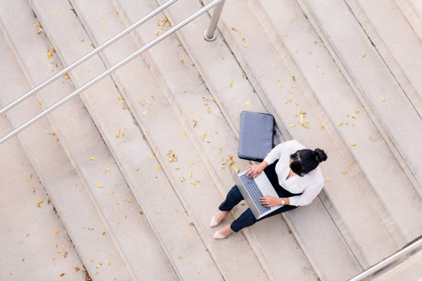 istock woman typing on computer on a concrete staircase 1360275028