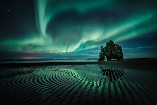 Iceland Landscape in the night, aurora borealis over beautiful legend stone Hvitserkur.