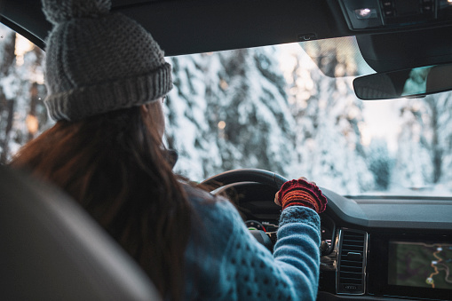 Woman driving a car on a snowy winter road