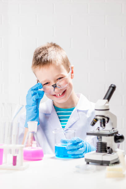 istock A schoolboy with a microscope examines chemicals in test tubes, conducts experiments - a portrait on a white background. Concept for the study of coronavirus in the laboratory 1360275849