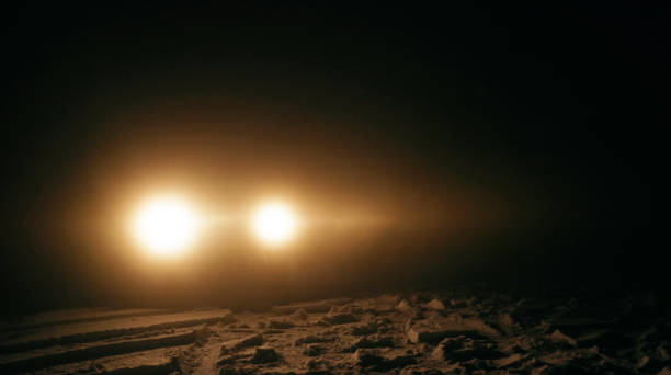 istock Car headlights at night. Car issues on winter road. 1360275869