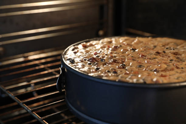 istock Large round traditional fruit or Christmas cake cooking in an oven 1360278564