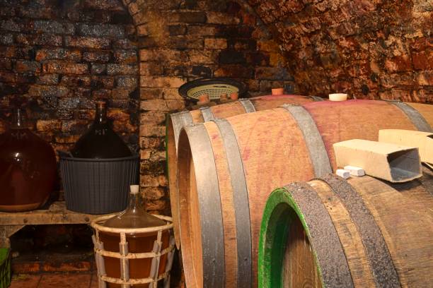istock Old cellar with demijohns and wooden barrels. Making wine traditionally 1360279921