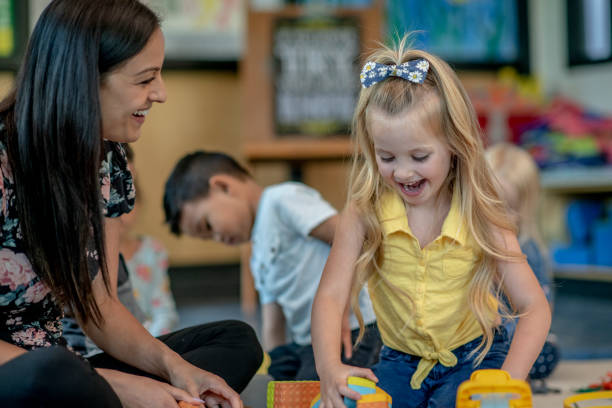 istock Preschool Students Playing in Classroom with Teacher 1360291968