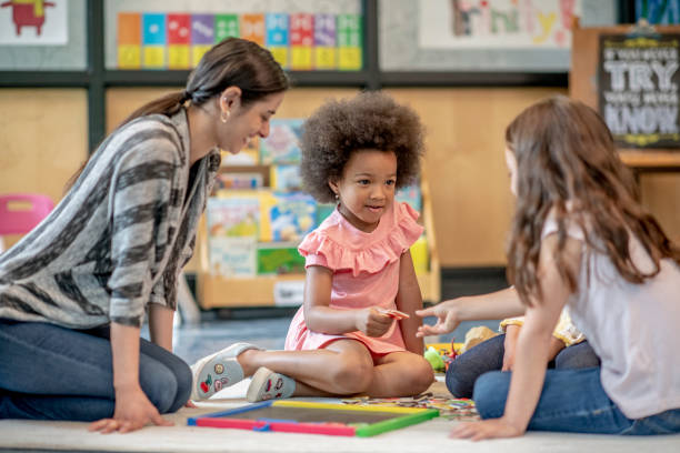 istock Preschool Students Playing with their Teacher 1360292001