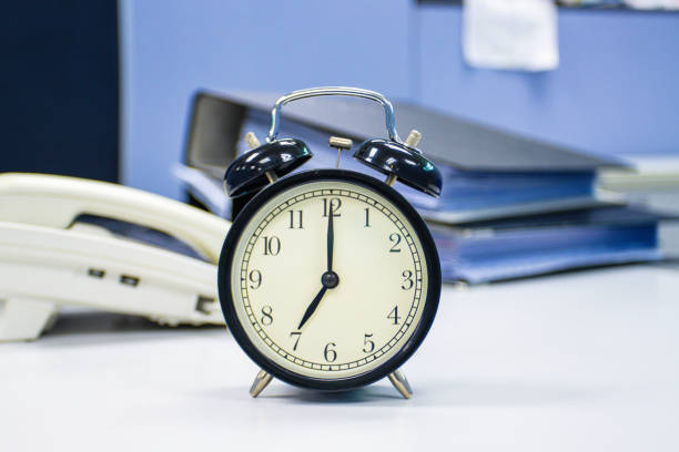 the clock on work desk in the office Time of businessman working concepts stock photo