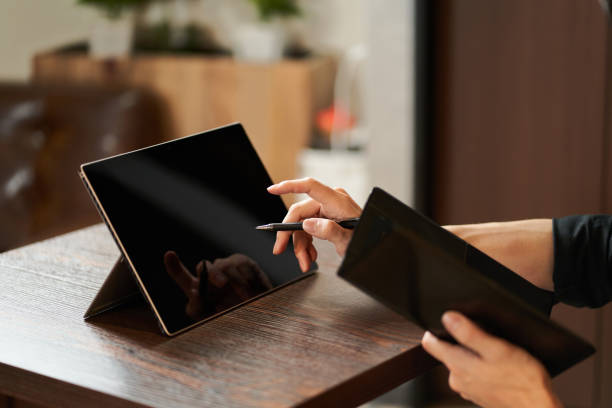 Asian clerk entering accounts on tablet