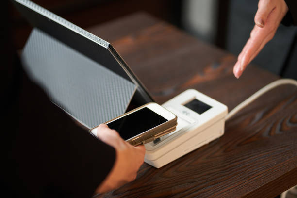 Hands of men making cashless payments