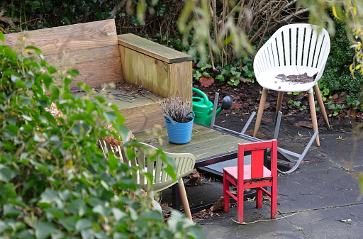 Backyard in the fall, selective focus on small red chair for children