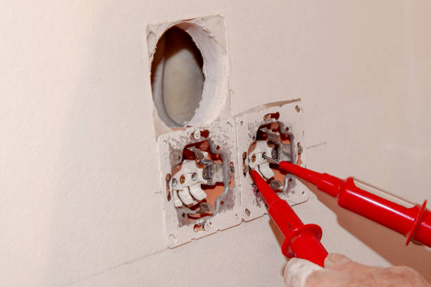 istock Hand of Electrician testing for electricity with a voltage tester. Electrician checking wall socket with voltage tester. 1360307745